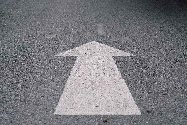 This image appears to be a road with a white-painted direction arrow denoting to move straight.