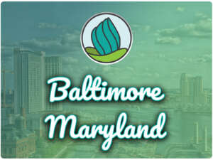 This image shows a water area with tall buildings in the background. In the top center, there is the logo of NDC and below there is the text " Baltimore Maryland"