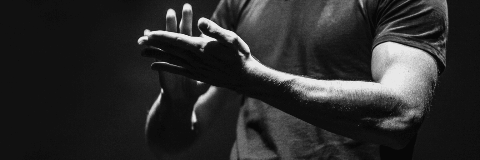 Imagen en blanco y negro del torso y los brazos de una persona mientras firma.