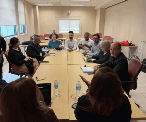 A group of people gathered around a table, including Tia, Kate, and UPR Rio Piedras Disability Services staff.